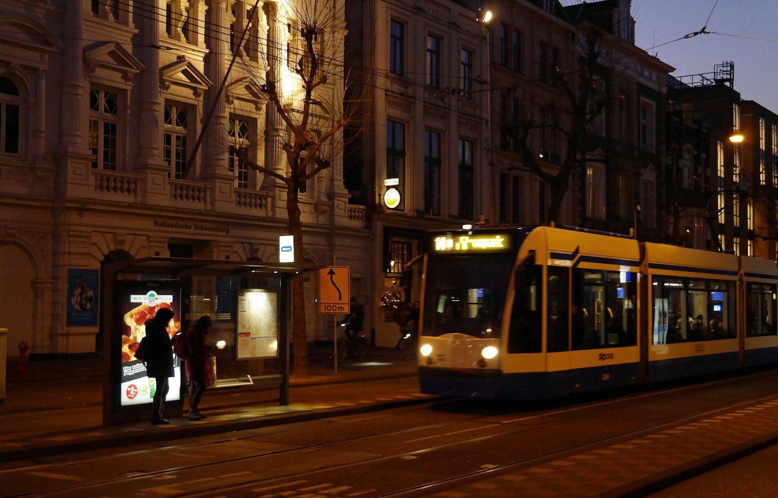 people walking on sidewalk near white and yellow tram during daytime