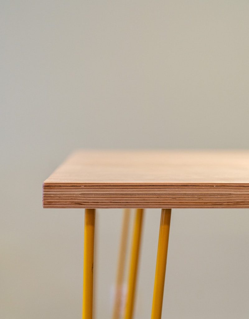 brown wooden table with yellow steel frame