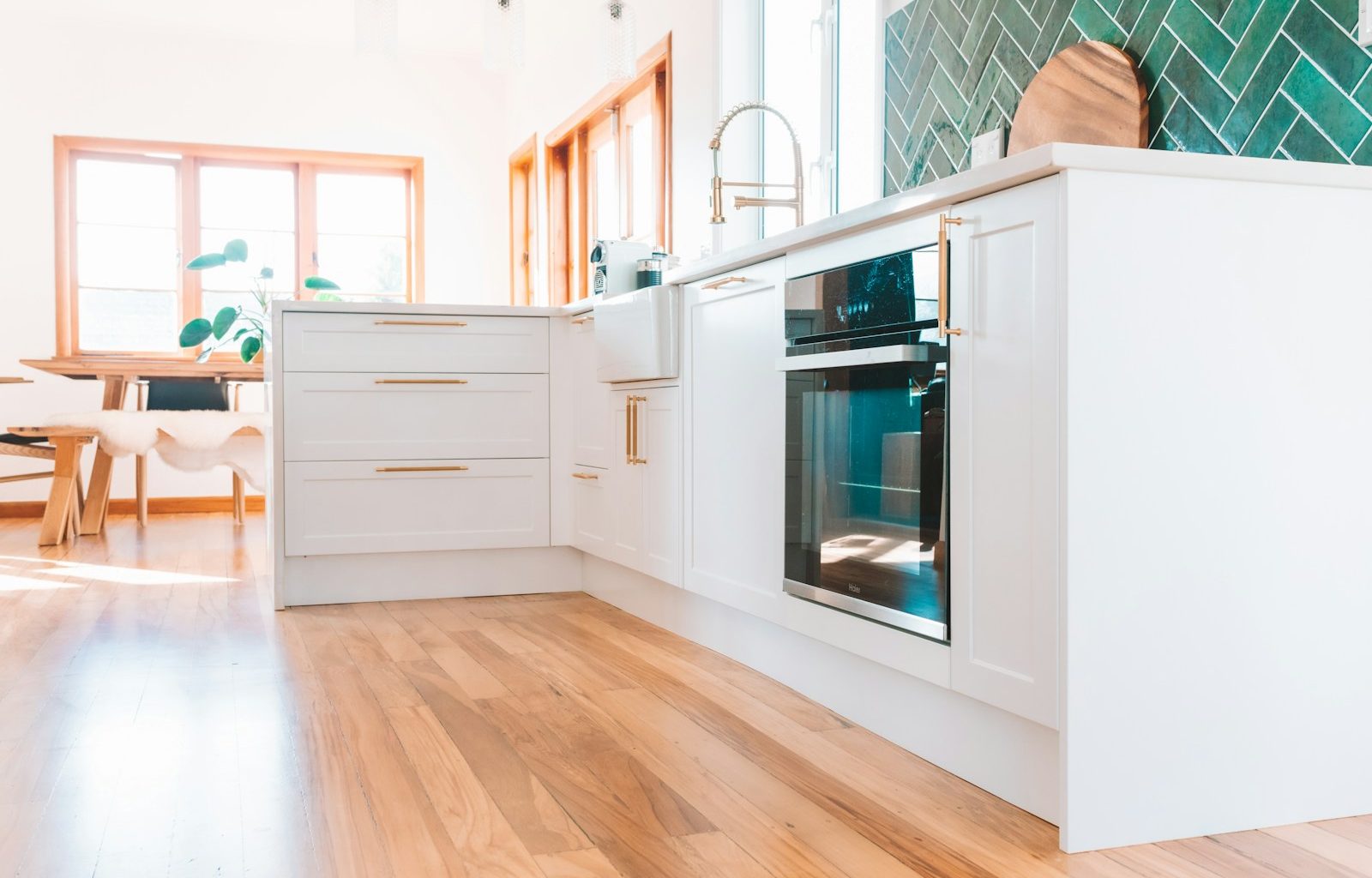 a kitchen with white cabinets and a wood floor