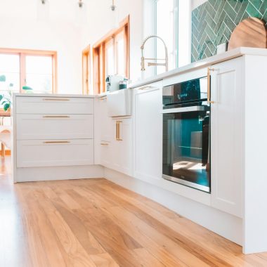 a kitchen with white cabinets and a wood floor