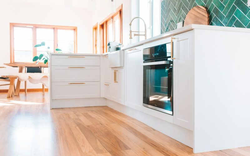 a kitchen with white cabinets and a wood floor