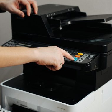 A person is pressing a button on a printer