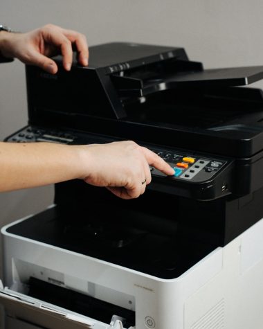 A person is pressing a button on a printer