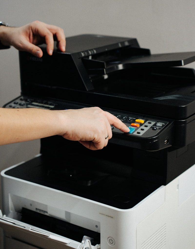A person is pressing a button on a printer