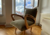 a chair sitting on a hard wood floor in front of a window