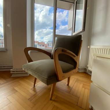 a chair sitting on a hard wood floor in front of a window
