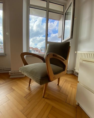 a chair sitting on a hard wood floor in front of a window