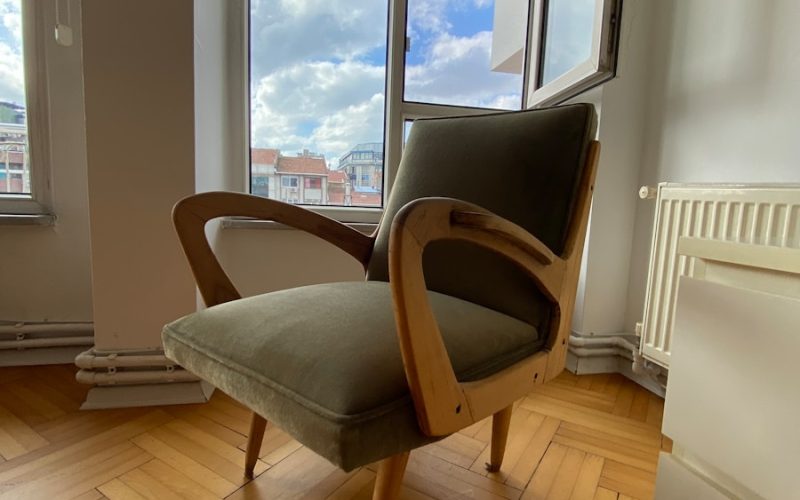 a chair sitting on a hard wood floor in front of a window