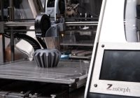Een 3D printer op een werkblad thuis die een object aan het printen is
