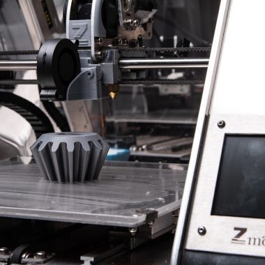 Een 3D printer op een werkblad thuis die een object aan het printen is