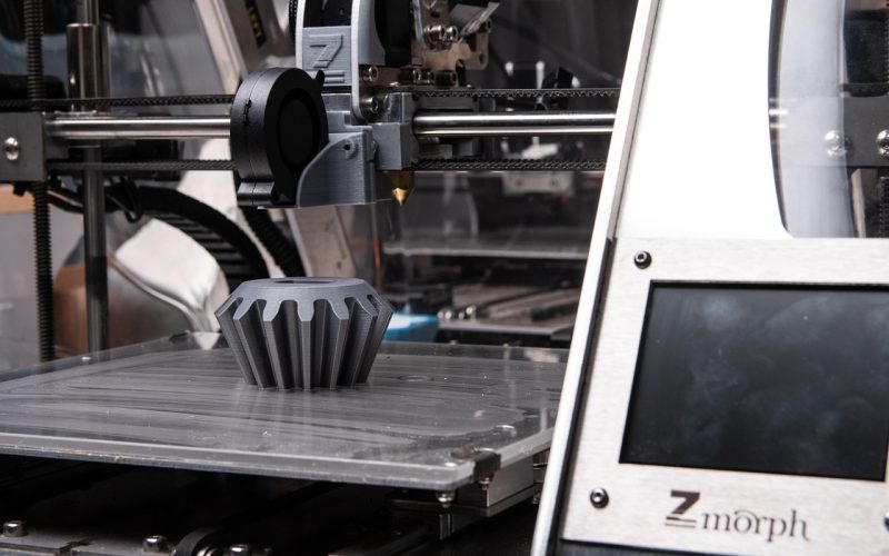 Een 3D printer op een werkblad thuis die een object aan het printen is
