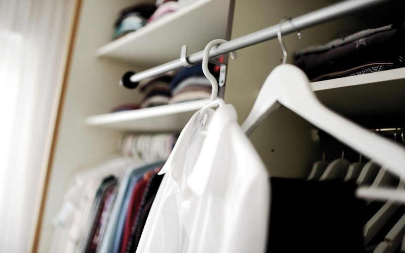 Zomerse kleding gesorteerd op bed bij het opruimen van de garderobe