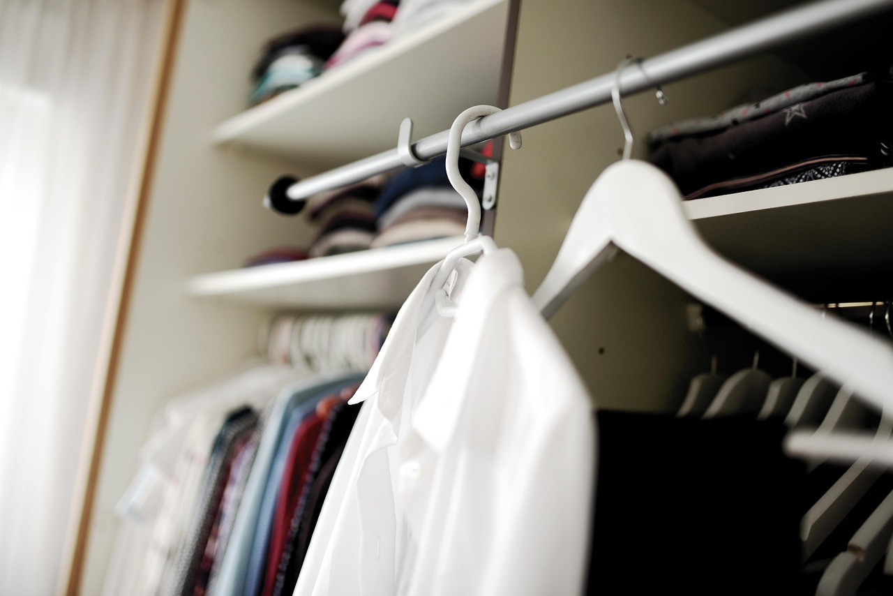 Zomerse kleding gesorteerd op bed bij het opruimen van de garderobe