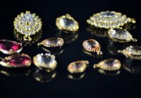 Gouden accessoires zoals kettingen, ringen en oorbellen gerangschikt op een lichte ondergrond