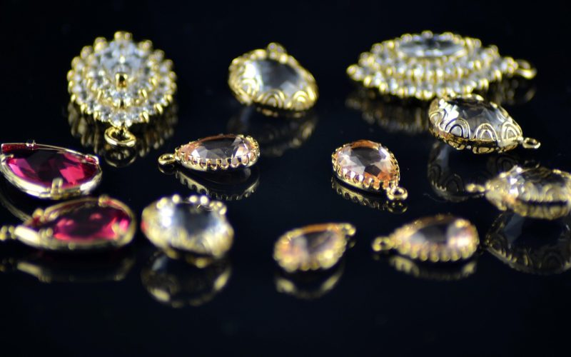 Gouden accessoires zoals kettingen, ringen en oorbellen gerangschikt op een lichte ondergrond