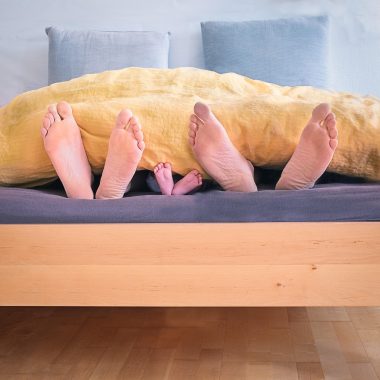 Lichte kinderkamer voor een peuter met houten meubels, lage opbergbakken en een zachte speelmat