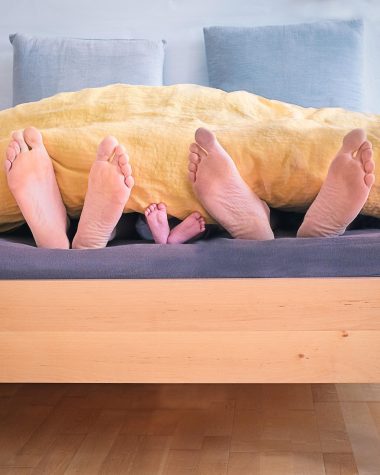 Lichte kinderkamer voor een peuter met houten meubels, lage opbergbakken en een zachte speelmat