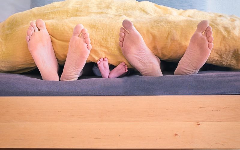Lichte kinderkamer voor een peuter met houten meubels, lage opbergbakken en een zachte speelmat