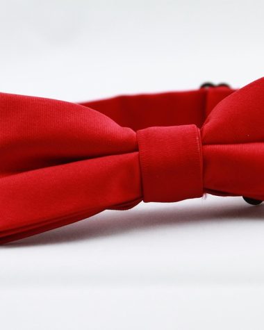 Verschillende rode kledingstukken en accessoires naast elkaar, waaronder een rode blouse, tas en sjaal in uiteenlopende tinten rood
