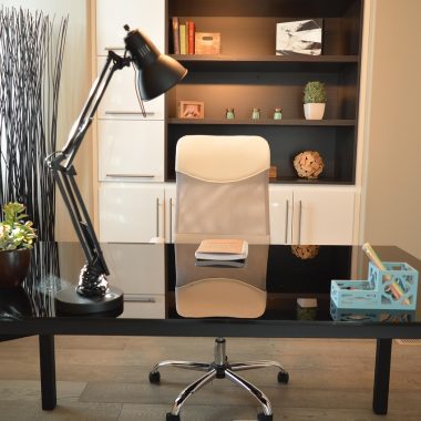 Ergonomische bureaustoel aan een thuiswerkplek met bureau en lamp