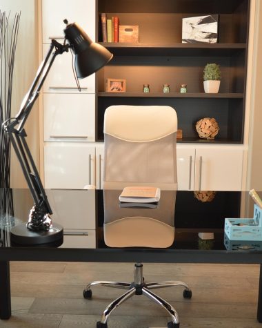 Ergonomische bureaustoel aan een thuiswerkplek met bureau en lamp