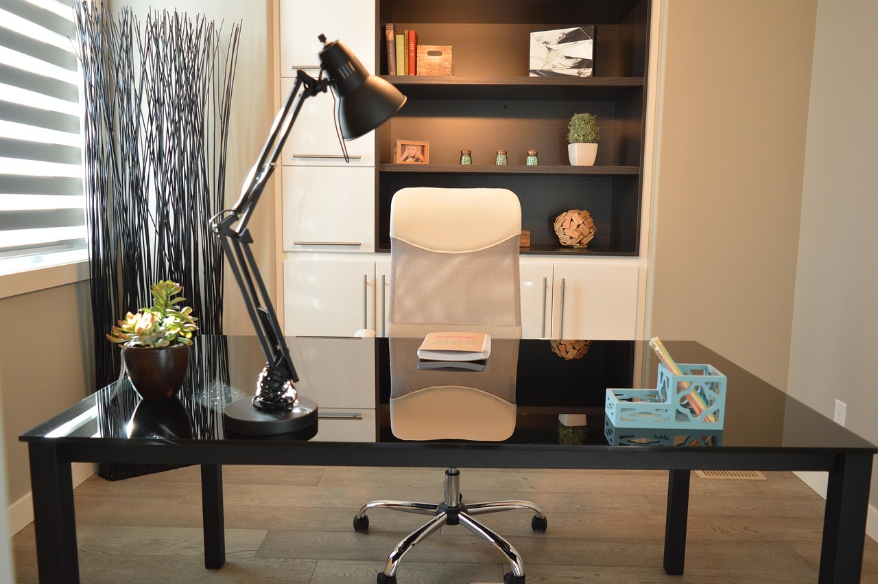Ergonomische bureaustoel aan een thuiswerkplek met bureau en lamp