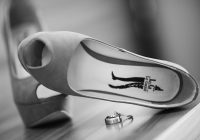 Witte bruidsschoenen met een elegante lage hak op een houten vloer