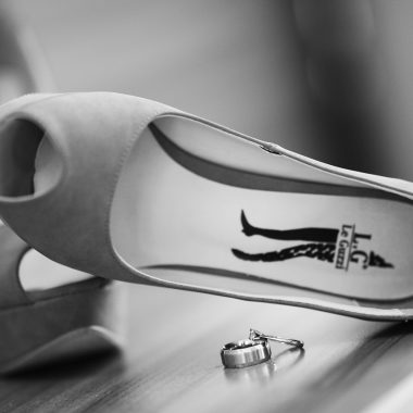 Witte bruidsschoenen met een elegante lage hak op een houten vloer