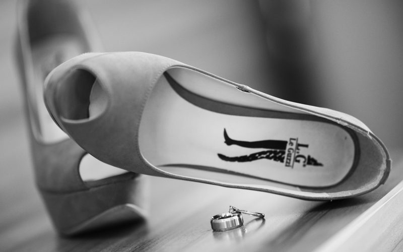 Witte bruidsschoenen met een elegante lage hak op een houten vloer