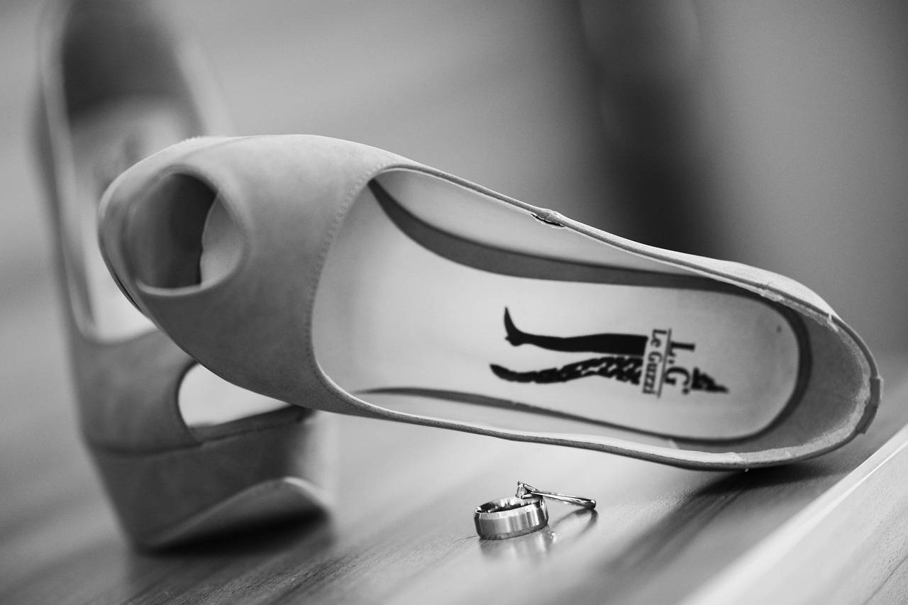 Witte bruidsschoenen met een elegante lage hak op een houten vloer