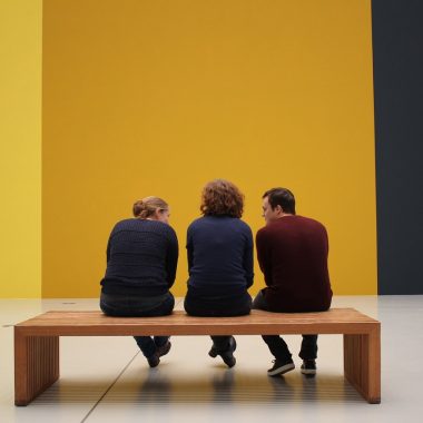 Een groep bezoekers luistert aandachtig naar een gids in een museum met moderne kunst