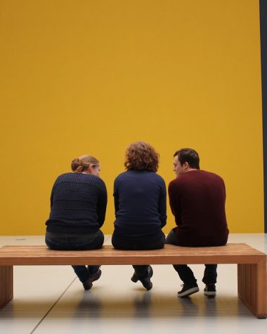 Een groep bezoekers luistert aandachtig naar een gids in een museum met moderne kunst