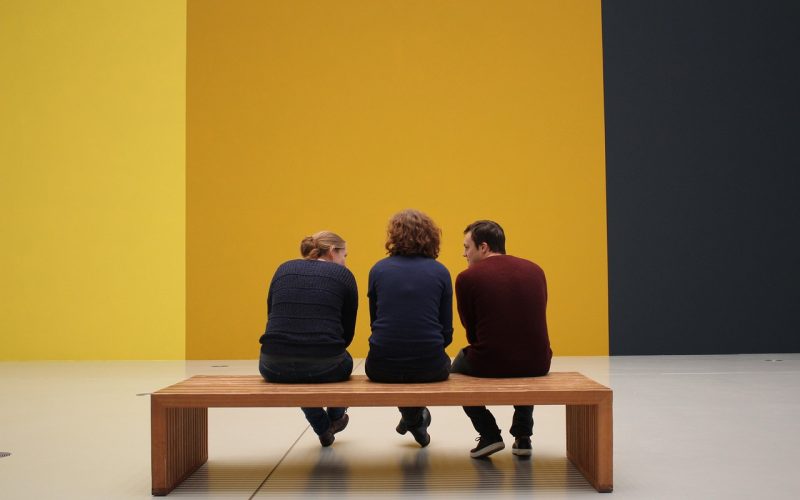 Een groep bezoekers luistert aandachtig naar een gids in een museum met moderne kunst