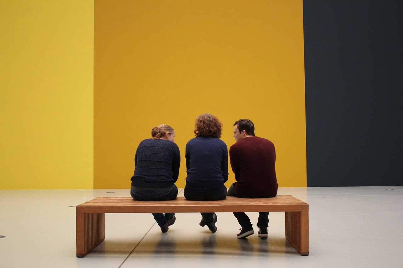 Een groep bezoekers luistert aandachtig naar een gids in een museum met moderne kunst
