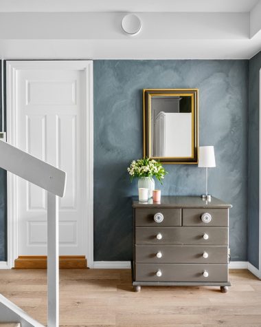 Gestylde hal met loper, spiegel en wandlamp voor een warme eerste indruk