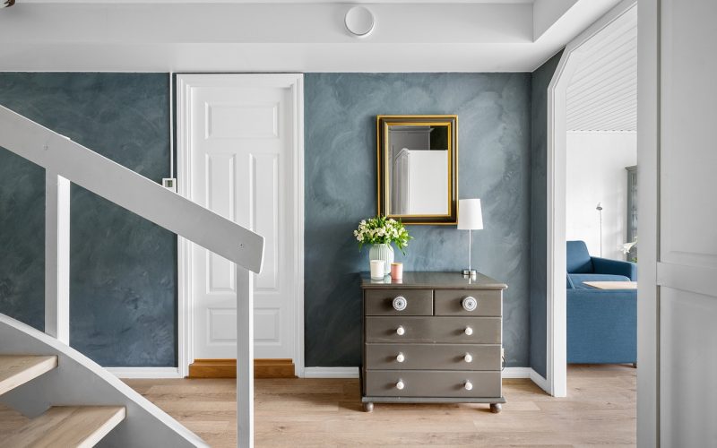 Gestylde hal met loper, spiegel en wandlamp voor een warme eerste indruk