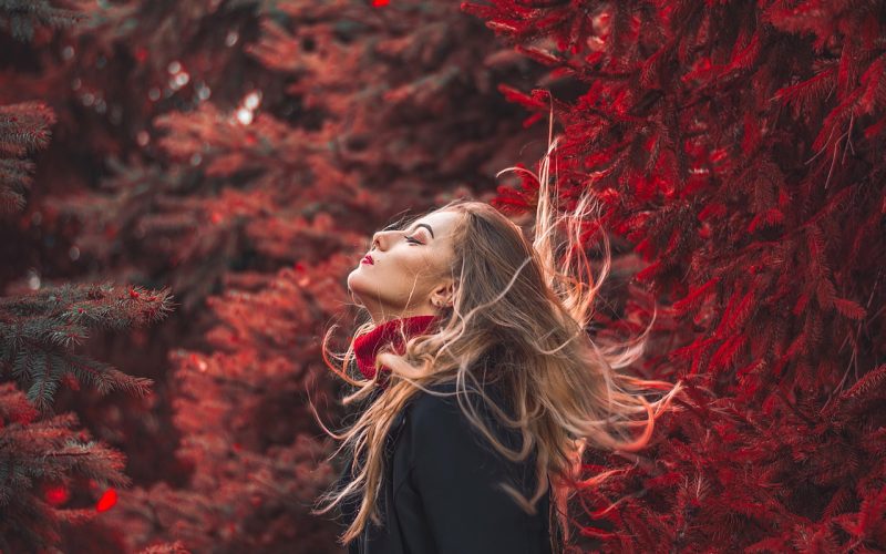 Werkende vrouw in een gelaagde herfstoutfit met cardigan en rechte broek