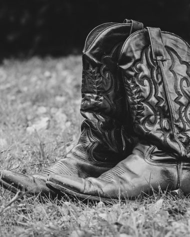 Verschillende herfstlaarzen in leer en suède naast een open kledingkast