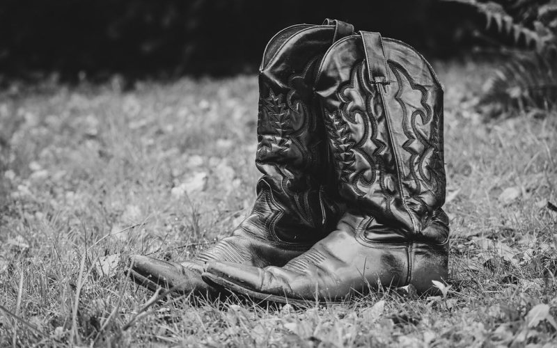 Verschillende herfstlaarzen in leer en suède naast een open kledingkast