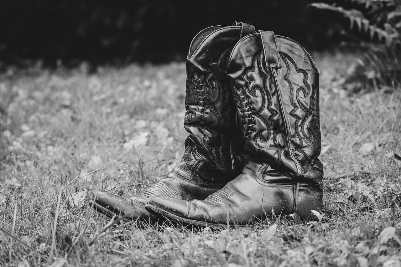 Verschillende herfstlaarzen in leer en suède naast een open kledingkast