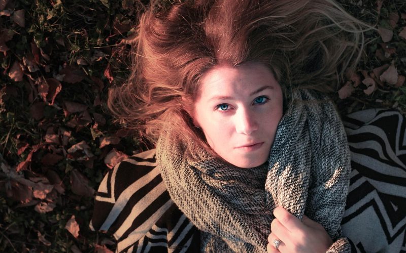 Vrouw met stijlvol gedrapeerde sjaal in herfstoutfit