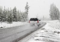 Auto langs een besneeuwde weg in de winter met hulpverlener