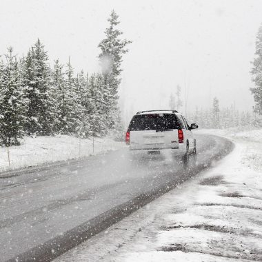 Auto langs een besneeuwde weg in de winter met hulpverlener