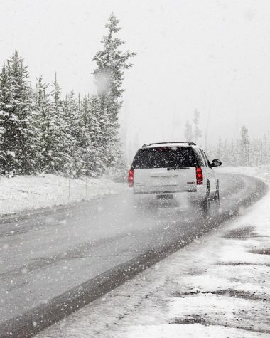 Auto langs een besneeuwde weg in de winter met hulpverlener