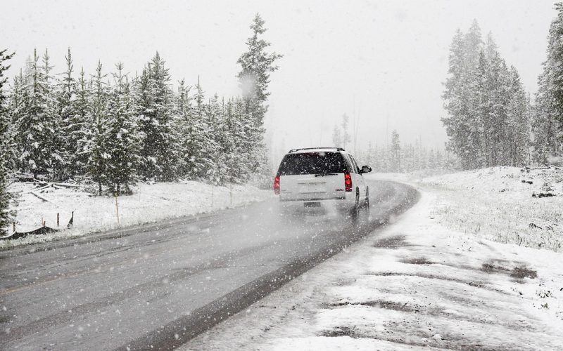 Auto langs een besneeuwde weg in de winter met hulpverlener