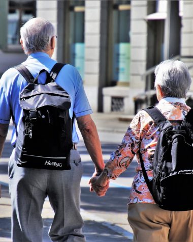 Senioren op een begeleide groepsreis stappen vrolijk uit een reisbus