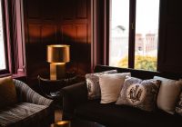 Een lichte woonkamer met een bouclé sofa in zandtint, gecombineerd met ribfluwelen kussens en een teddy plaid