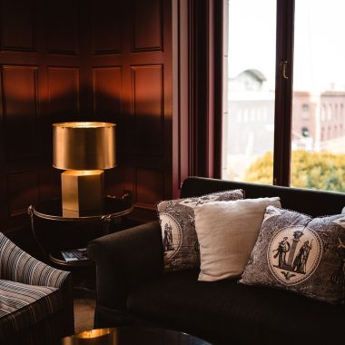 Een lichte woonkamer met een bouclé sofa in zandtint, gecombineerd met ribfluwelen kussens en een teddy plaid