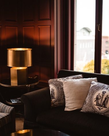 Een lichte woonkamer met een bouclé sofa in zandtint, gecombineerd met ribfluwelen kussens en een teddy plaid