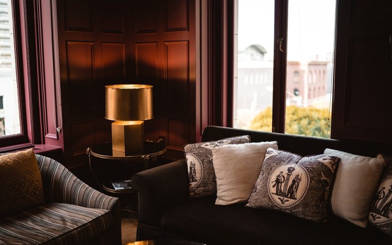 Een lichte woonkamer met een bouclé sofa in zandtint, gecombineerd met ribfluwelen kussens en een teddy plaid